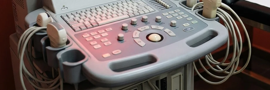 Detalhe do painel de controle do aparelho de ultrassom, com teclado e transdutores.